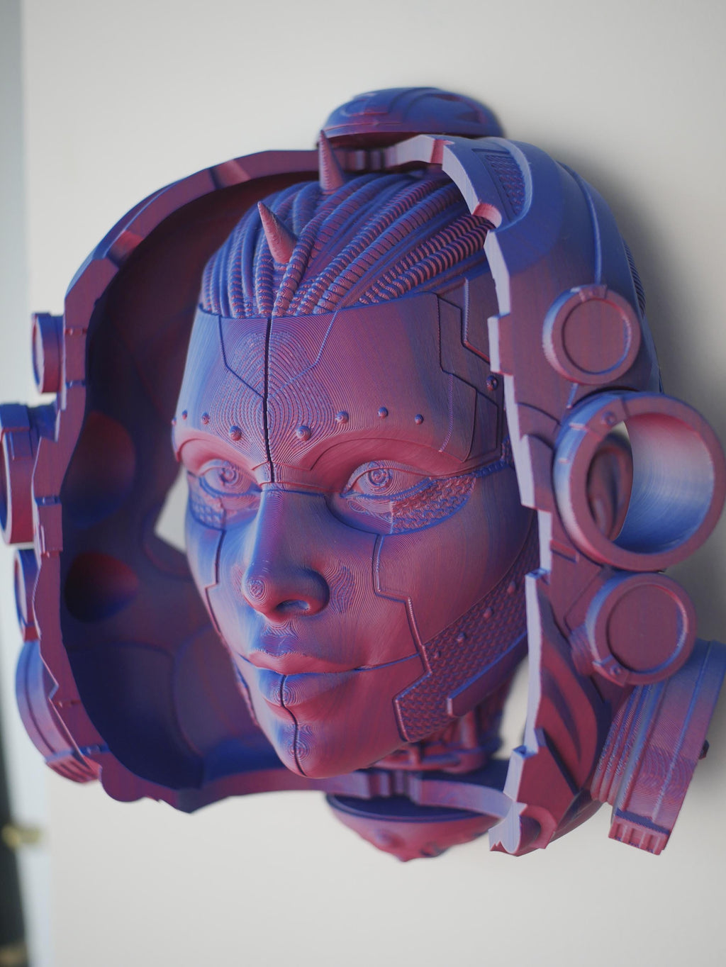 Esta impresionante escultura de cabeza impresa en 3D se abre para revelar una cara de androide oculta, perfecta para su pared o escritorio con el soporte incluido.