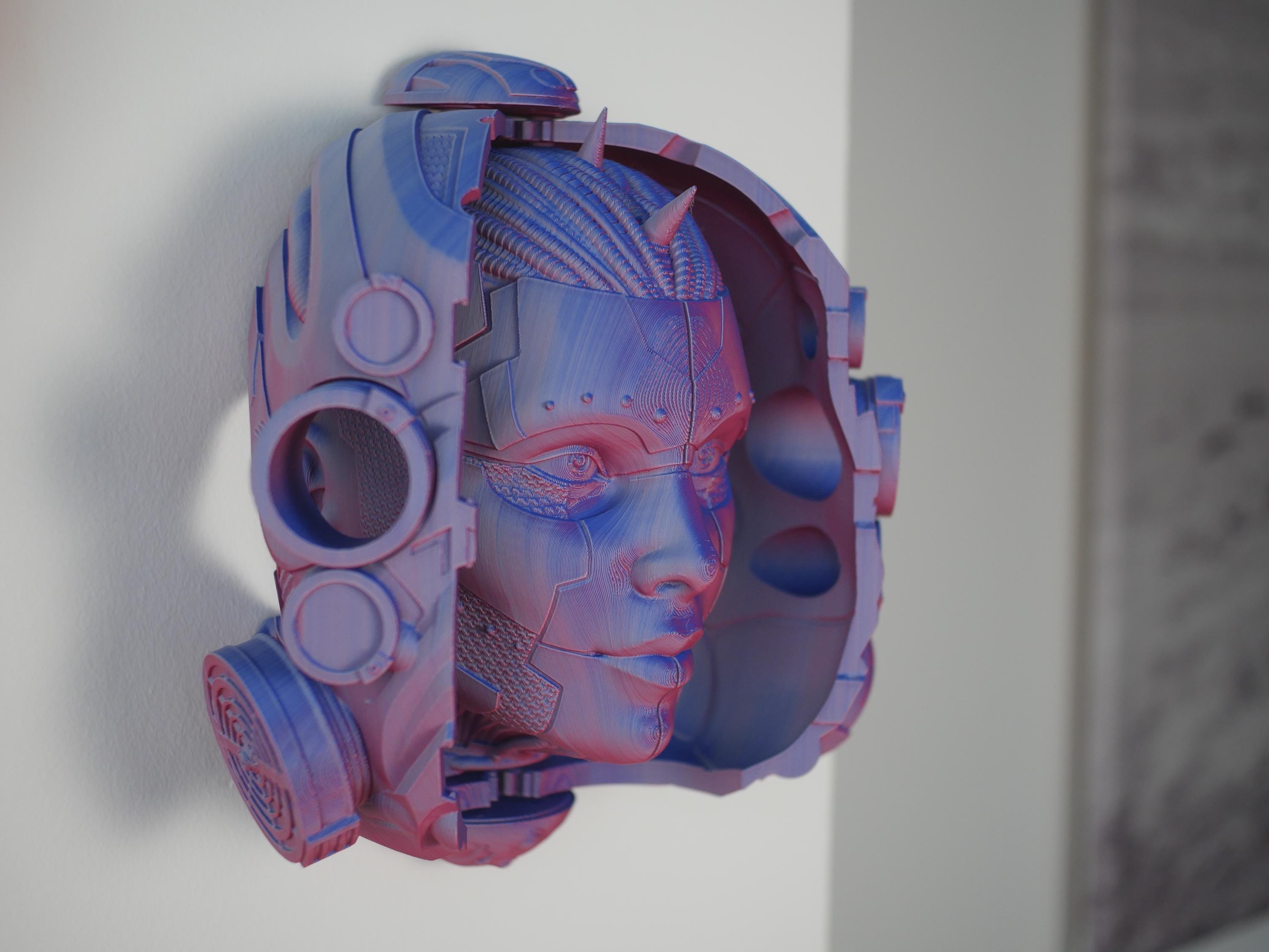 Esta impresionante escultura de cabeza impresa en 3D se abre para revelar una cara de androide oculta, perfecta para su pared o escritorio con el soporte incluido.