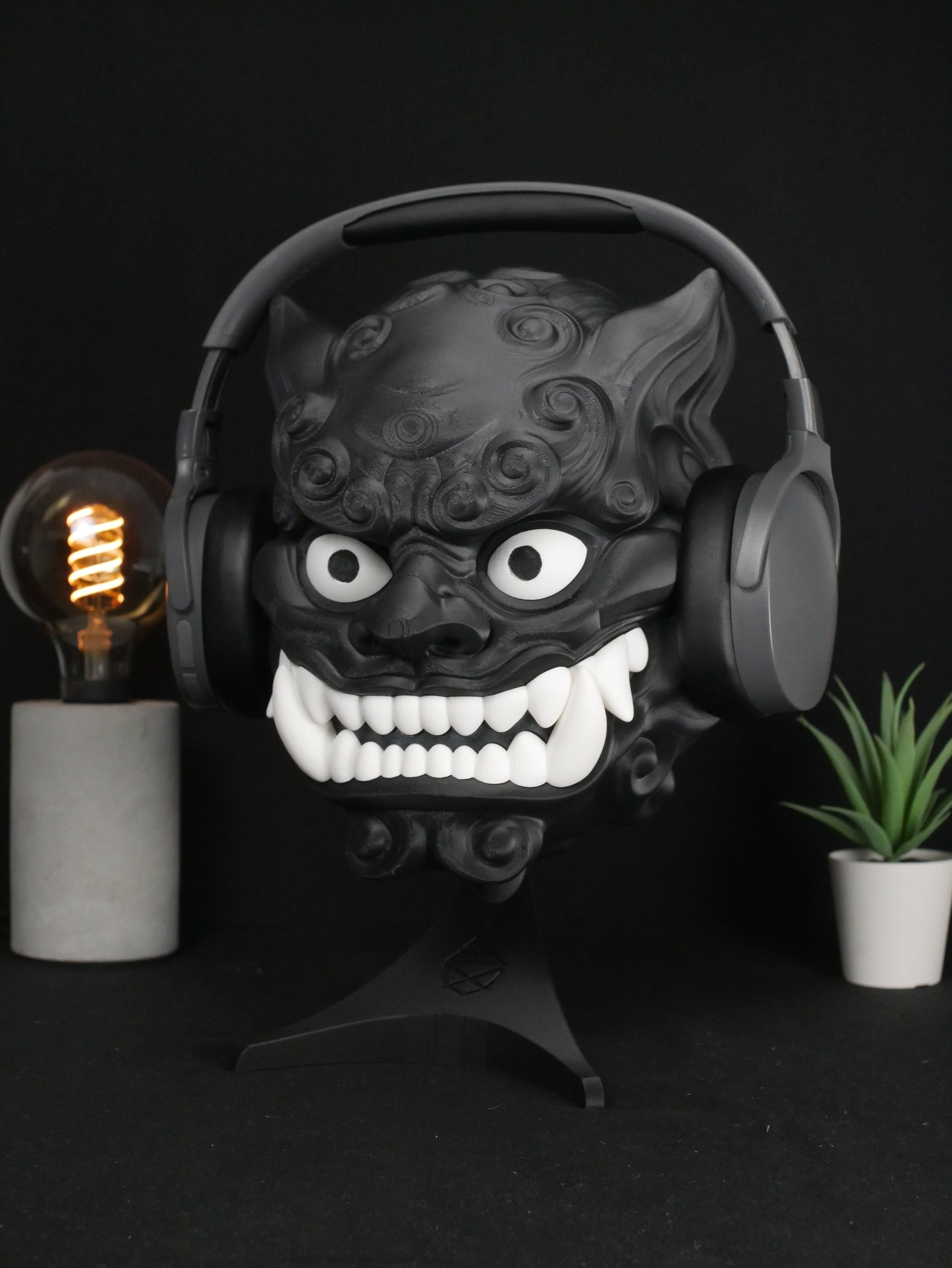 Soporte para auriculares Foo Dog personalizable sujetando cascos grises.