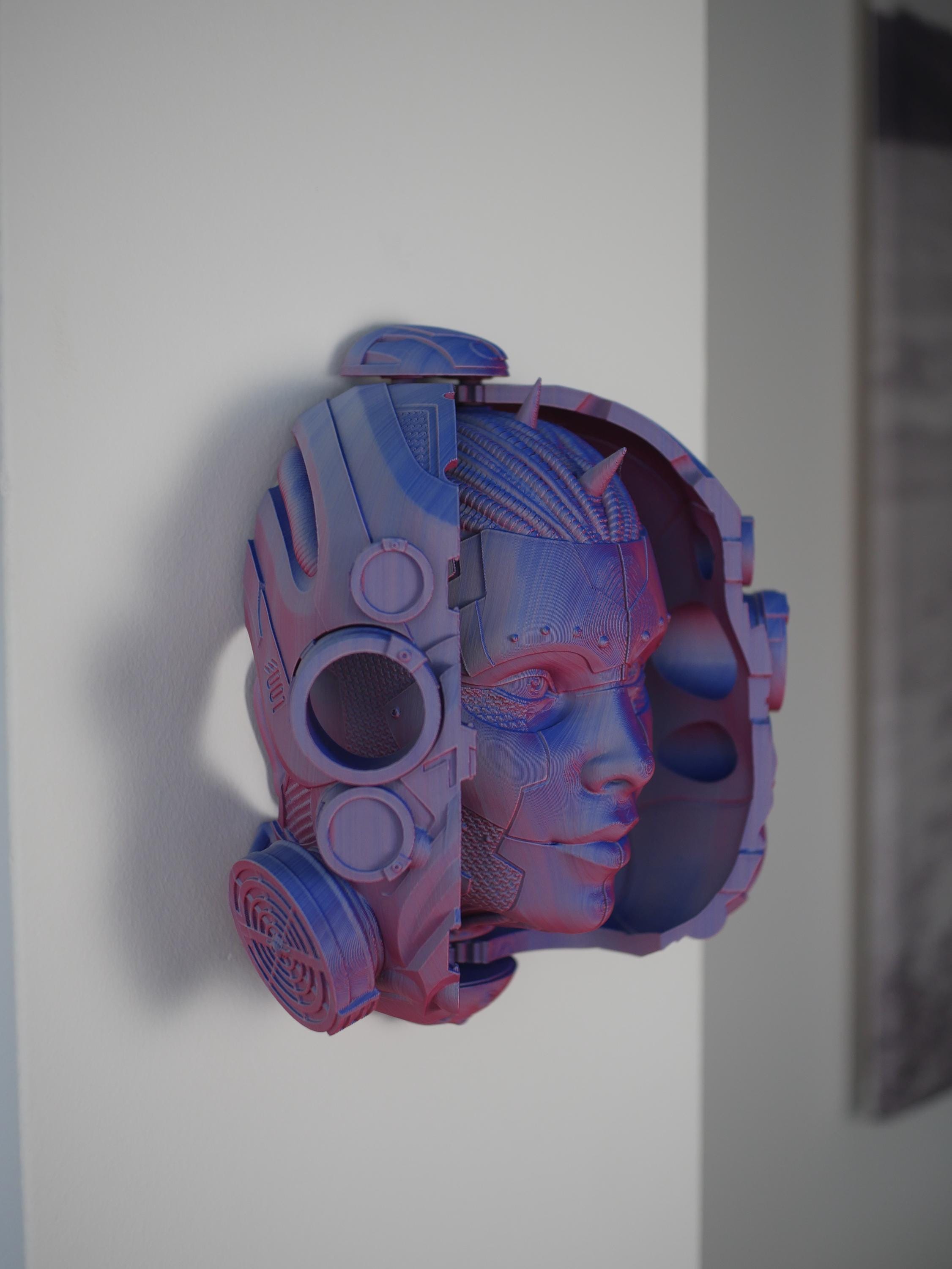 Esta impresionante escultura de cabeza impresa en 3D se abre para revelar una cara de androide oculta, perfecta para su pared o escritorio con el soporte incluido.