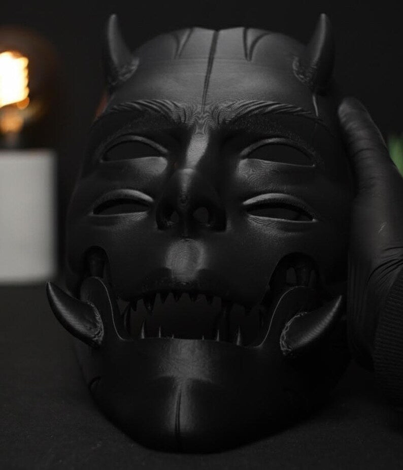 Máscara de demonio Argos con la mandíbula articulada abierta, mostrando los dientes